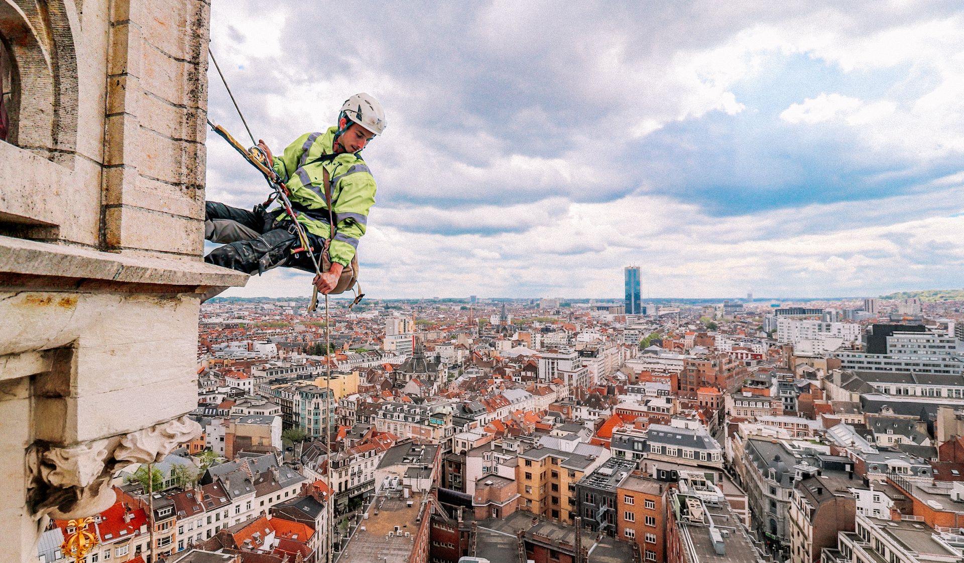 technicien cordiste des Suspendus, équipé de son harnais et de son matériel de sécurité, en intervention sur une façade
