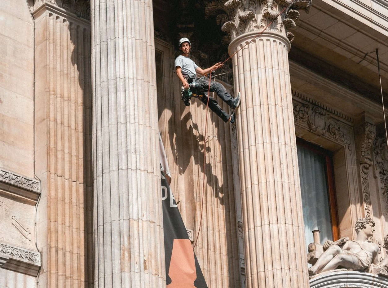 Cordiste remettant en place des bâches suite à une tempête sur La Bourse en accès difficile à Bruxelles