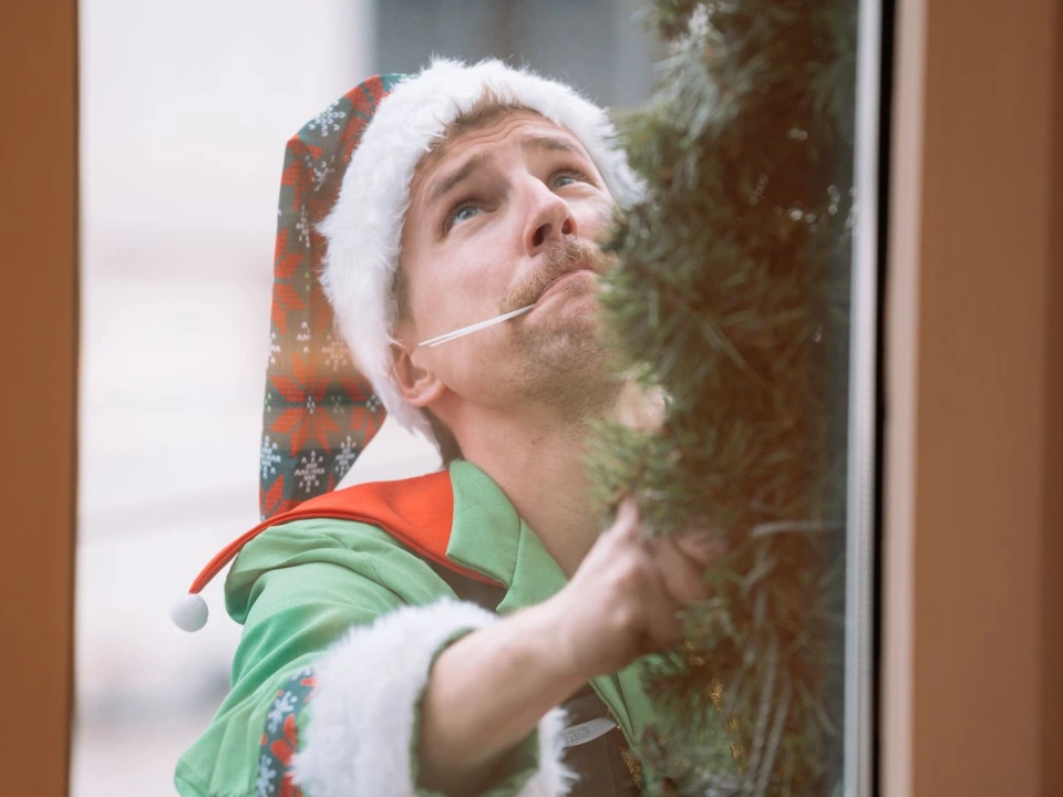Cordiste mettant en place des décorations de Noël sur la boutique Bobbies en accès difficile à Bruxelles