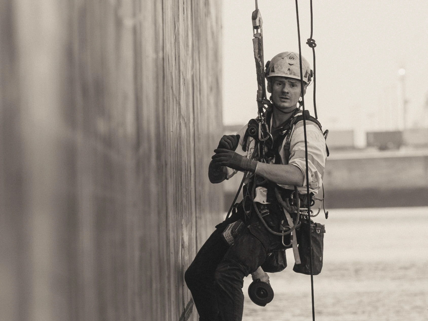 Cordiste réalisant la remise en peintre de la coque d'un porte-container en accès difficile au Port d'Anvers